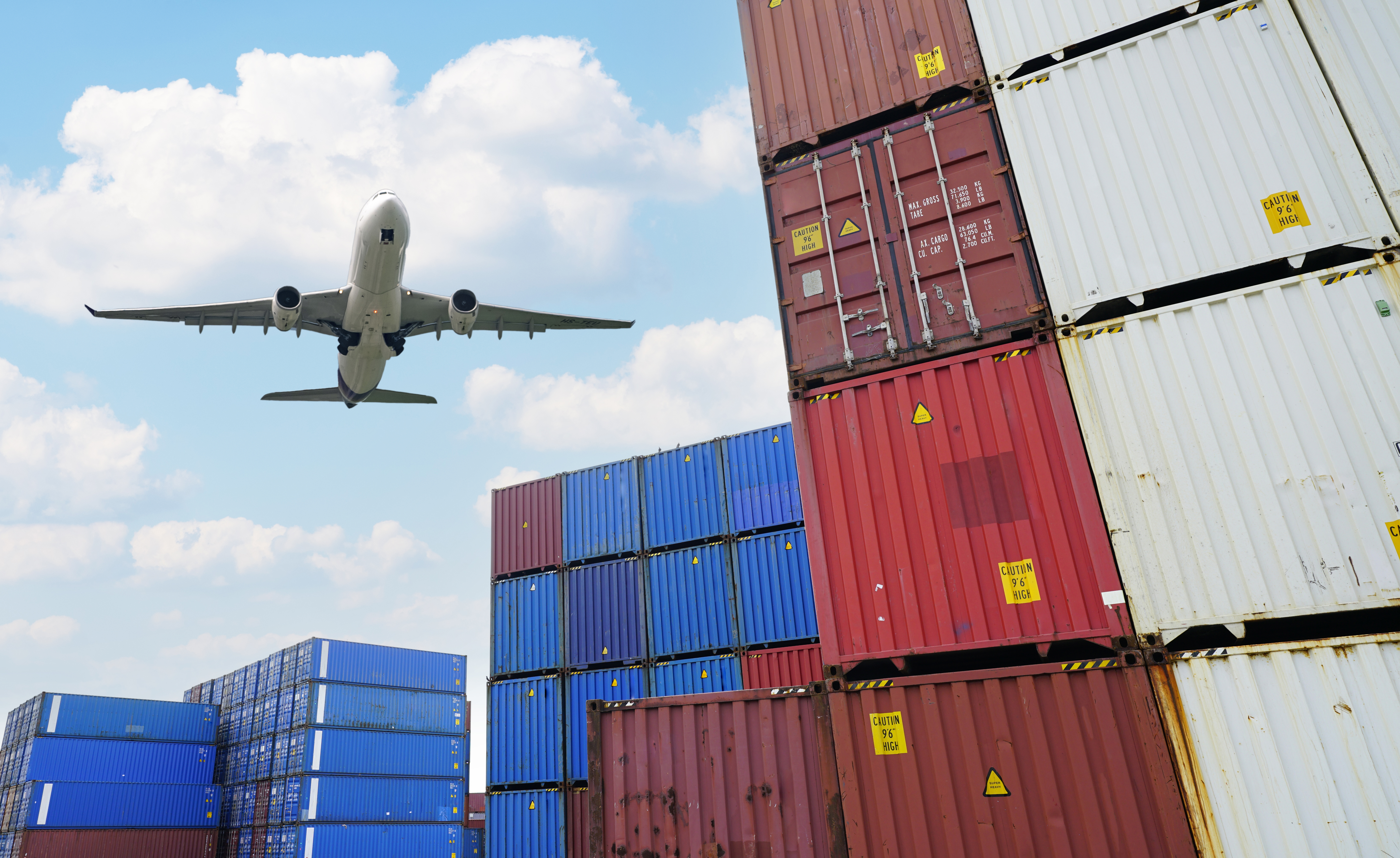 Cargo airplane flying above logistic container. Air logistic. Cargo and shipping business. Container